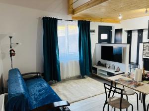 un soggiorno con divano blu e tavolo di Reny's Studio Apartments -Hiperbara a Livezeni