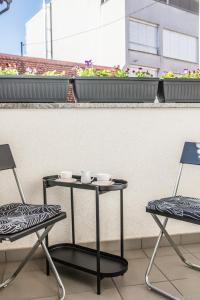 twee stoelen en een tafel en twee kopjes op een balkon bij Apartman BeBe in Zagreb