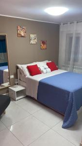 una camera da letto con un grande letto con cuscini rossi di LAGUNA BLU Camera TRAMONTO con terrazza panoramica in comune a Chioggia