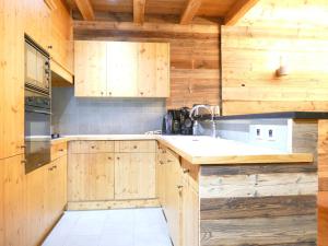 una cocina con armarios de madera y fregadero en Appartement Les Deux Alpes, 5 pièces, 12 personnes - FR-1-546-13, en Les Deux Alpes