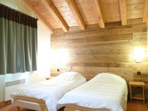 2 camas en una habitación con pared de madera en Appartement Les Deux Alpes, 5 pièces, 12 personnes - FR-1-546-13, en Les Deux Alpes