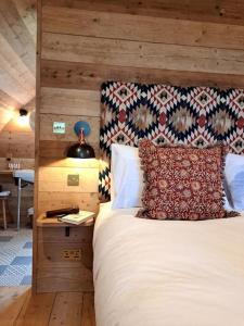 a bedroom with a bed with a wooden wall at The Pigsty in Crieff