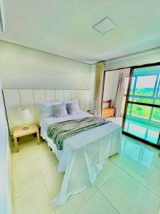 a bedroom with a bed and a large window at Lindo Apartamento no Condomínio Alto da Serra Villas de Bananeiras in Bananeiras