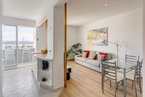 Tejo River View Apartment nearby Belém في لشبونة: غرفة معيشة مع طاولة زجاجية وأريكة