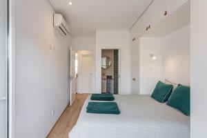 a bedroom with a large white bed with green pillows at Tejo River View Apartment nearby Belém in Lisbon
