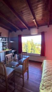 een woonkamer met een tafel en stoelen en een bed bij Astrolabio Hostel in Bariloche