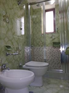 y baño con aseo, lavabo y ducha. en Casa Buenos Aires, en Massa Lubrense