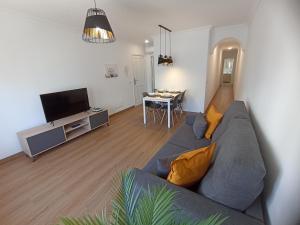uma sala de estar com um sofá cinzento e uma mesa em BL Holidays em Arrecife