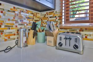 a kitchen with a counter with a toaster and knives at Cheerful 3 -bedroom villa with Pool in Tortola Island