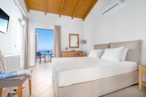 a bedroom with a bed and a view of the ocean at Pelagia Aphrodite Hotel in Agia Pelagia