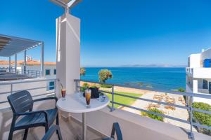 a balcony with a table and chairs and a view of the ocean at Pelagia Aphrodite Hotel in Agia Pelagia