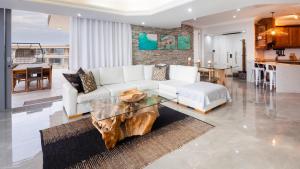sala de estar con sofá blanco y mesa de madera en Beachfront Penthouse Ballito en Ballito