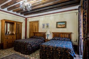 a bedroom with two beds and a chandelier at Hotel Boutique Casa de la Palma in Puebla