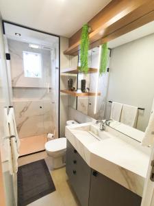 a bathroom with a sink and a toilet and a shower at Apartamento ao lado da Vila Germânica in Blumenau