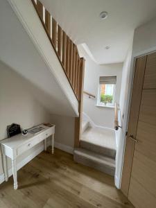 a room with a staircase with a desk and a window at Newly renovated 3 Bed property - countryside views in Dunstall