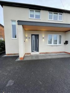 a white house with a black door and a driveway at Newly renovated 3 Bed property - countryside views in Dunstall