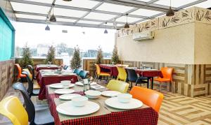 un restaurante con mesas y sillas y una gran ventana en Treebo Trend Classic Grande, Camp en Pune