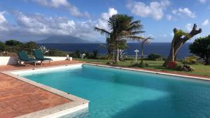 a swimming pool with a view of the ocean at Statia Lodge in Oranjestad