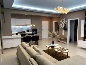 SAS 2 Luxury Apartments في مامايا: غرفة معيشة مع أريكة ومطبخ