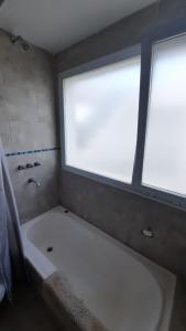 a large bath tub in a bathroom with a window at Bernal Alquileres in Viedma