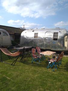 a group of chairs and a table in front of a trailer at Guest House Uminokyojyusya - Vacation STAY 04260v in Miyazaki