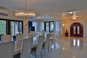 a dining room with a long table and chairs at Modern 3-bedroom villa with pool in Tortola Island