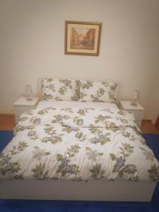 een bed met een wit dekbed en twee nachtkastjes bij Family & Group Stay in Zagreb