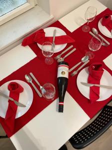 a table with red and white plates and wine glasses at Nice apartment between Schönbrunn and Karlsplatz in Vienna