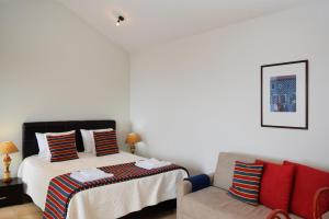 - une chambre avec un lit et un canapé dans l'établissement Cicas Studio, a Home in Madeira, à Arco da Calheta