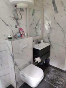 a white bathroom with a toilet and a sink at Apartman Oaza - Ploče, Croatia in Ploče