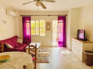 ein Wohnzimmer mit lila Vorhängen und einer roten Couch in der Unterkunft Sunny apartment Aldea Del Mar near the sea in Torrevieja