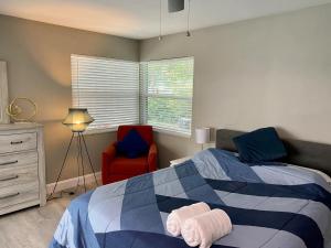 a bedroom with a bed and a red chair at Spacious 5 bedrooms 3 bathrooms Family-Friendly Home With Heated salt Pool in Clearwater