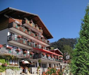 a large building with balconies and flowers on it at Hôtel Les Triolets in Châtel