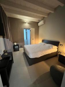 Un dormitorio con una cama grande y una ventana en V&B Suites and Apartments, en Pavia