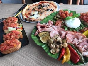 uma mesa coberta com pratos de comida e uma pizza em Pension und Restaurant Die Burg em Ehrenfriedersdorf