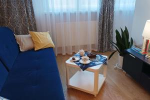 a living room with a blue couch and a table at Apartament Sztygara in Mikołów