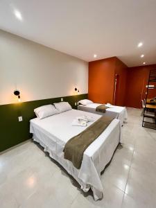 two beds in a room with green walls at Pousada Primavera in Parnaíba