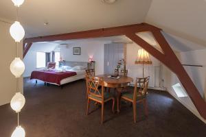 Habitación con mesa, cama y dormitorio. en Hotel de Gaaper en Amersfoort