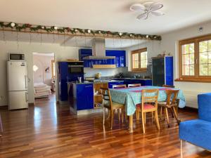 a kitchen with blue cabinets and a table and chairs at Guardaval in Arosa