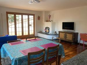 ein Wohnzimmer mit einem Tisch und einem TV in der Unterkunft Guardaval in Arosa