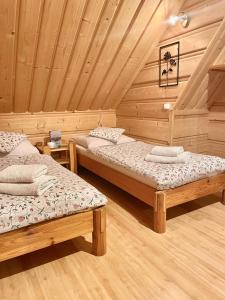 ブコビナ・タトシャンスカにあるTaternicaの木製天井のドミトリールームのベッド2台分です。