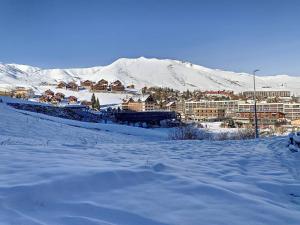 eine Stadt im Schnee mit einem Berg im Hintergrund in der Unterkunft 2 Pièces 6 Pers Sud à 150m des Pistes - FR-1-416-4 in La Toussuire
