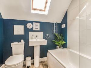 a bathroom with a toilet and a sink and a tub at Lantern House in Filey +19 photos