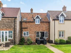 a brick house with a patio and lawn at Lantern House in Filey