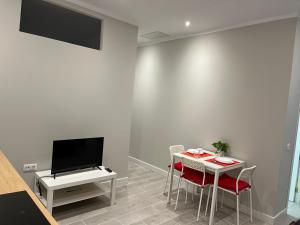 a room with a table and a tv and a table and chairs at Casa Paraiso Tenerife in Los Abrigos