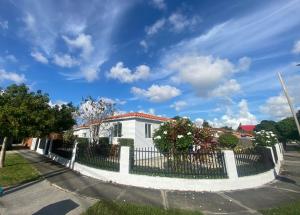 una casa blanca con una valla en una calle en Main House 3 Bed 2 Bath & Guest House 1 Bed 1 Bath en Miami