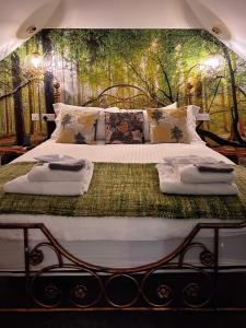 1 dormitorio con 1 cama grande y pared verde en Luxury tree-house with optional ESPA Spa, en Canterbury