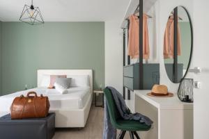 um quarto com uma cama, um espelho e uma cadeira em Family Terrace Suite - Volturno3 Suites & more em Mazara del Vallo