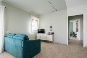 uma sala de estar com um sofá azul e uma mesa em Family Terrace Suite - Volturno3 Suites & more em Mazara del Vallo
