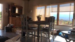cocina con mesa, sillas y ventana en Los Chañares en San Carlos